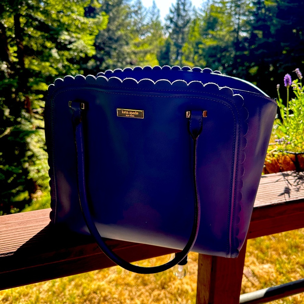 Kate Spade blue bag with tulip cut design on top edge. No scratches